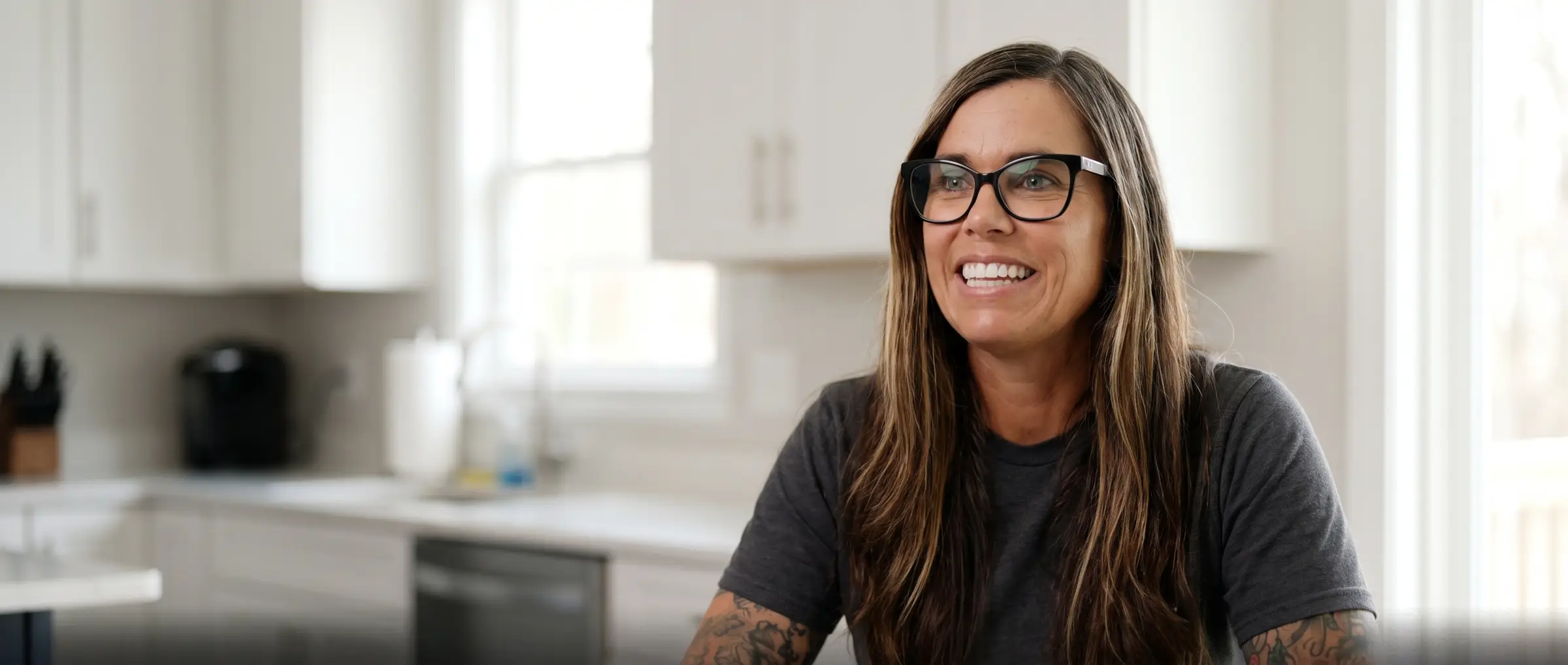 Amanda, owner of The Modern Maid, smiling in a bright, freshly cleaned kitchen